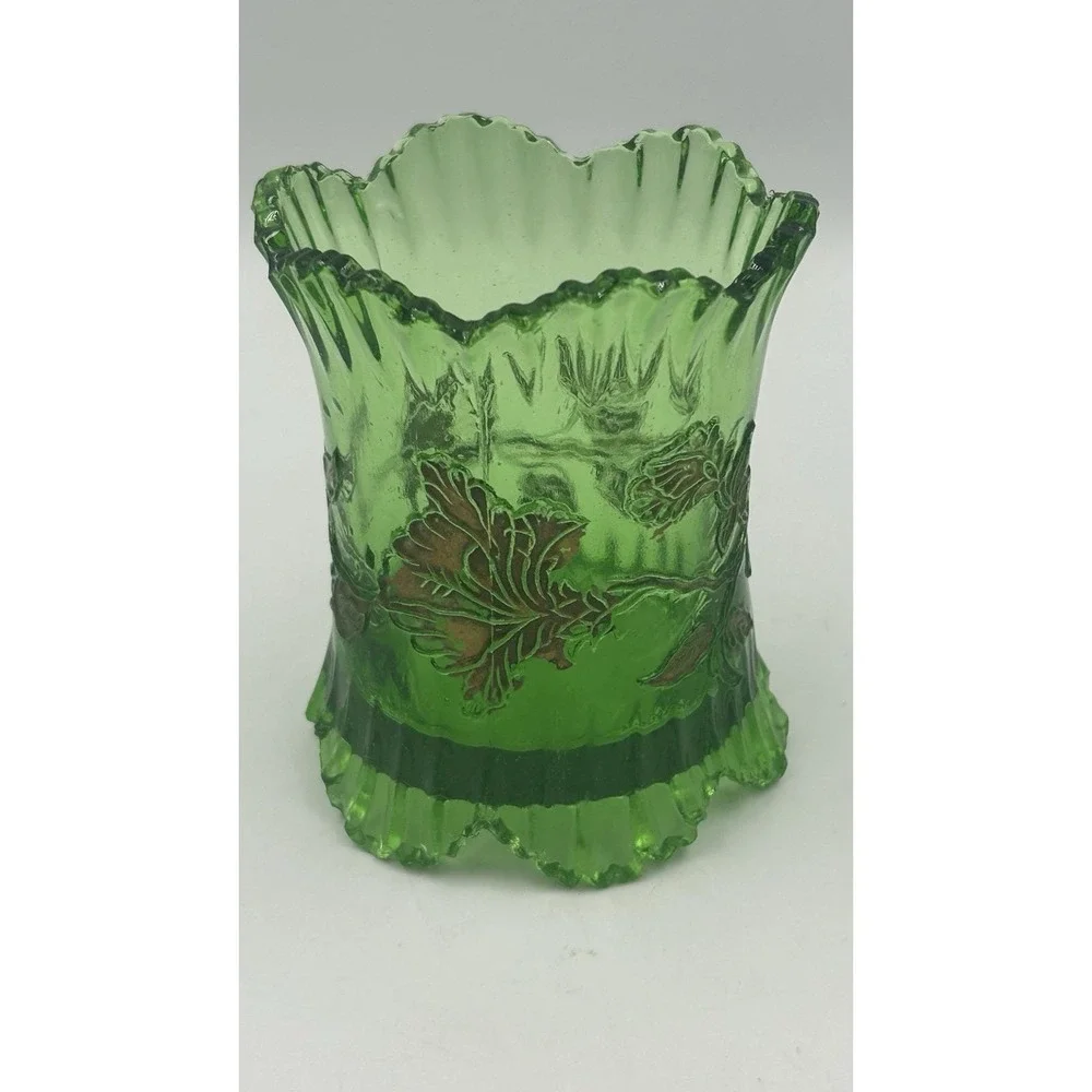 An Antique EAPG green glass spoon holder with gold floral overlay.